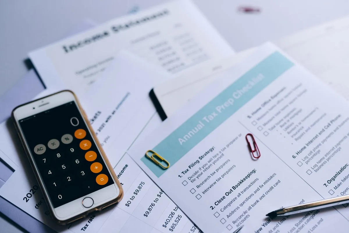 Calculator resting on financial documents showing loan calculations