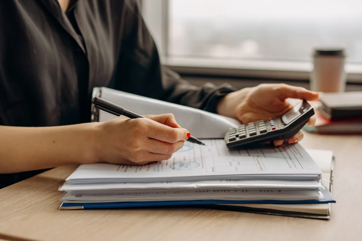Calculator resting on business financial documents and spreadsheets