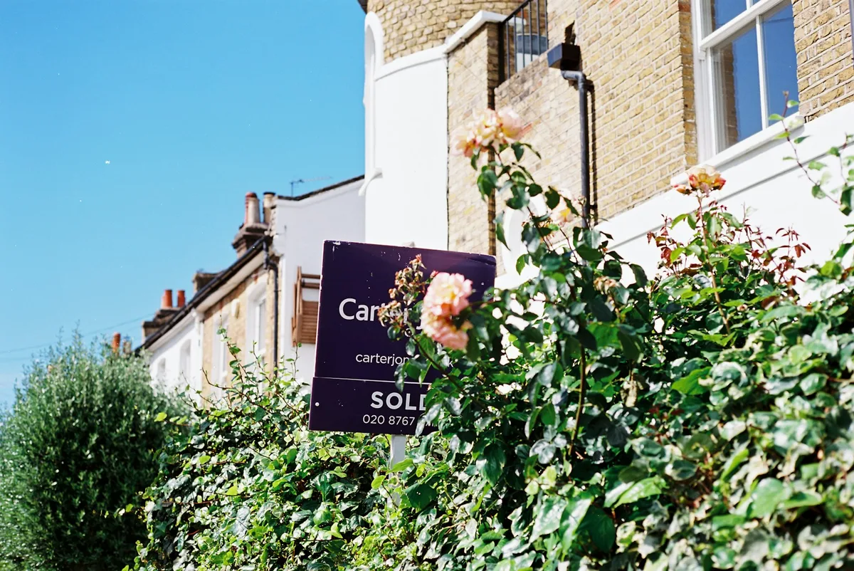 Property for sale sign in front of residential home