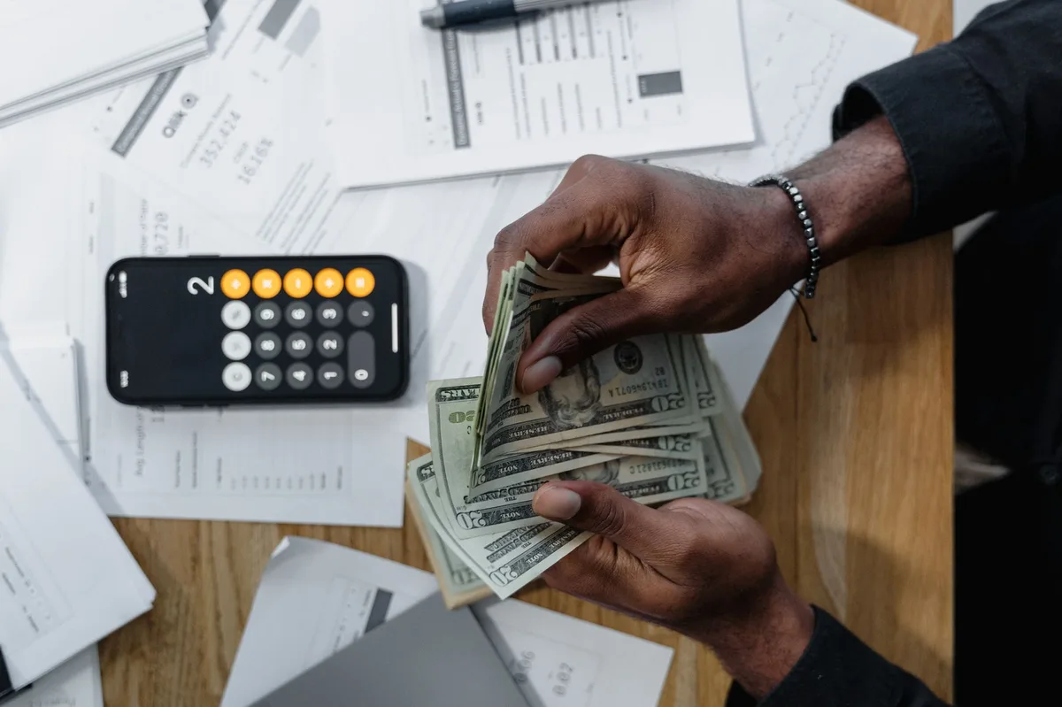 Calculator with coins on financial documents representing LMI cost calculations