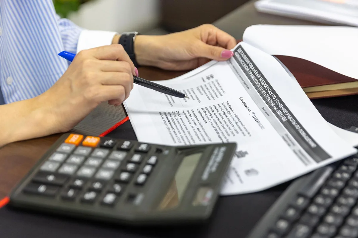 Calculator resting on mortgage documents and financial paperwork