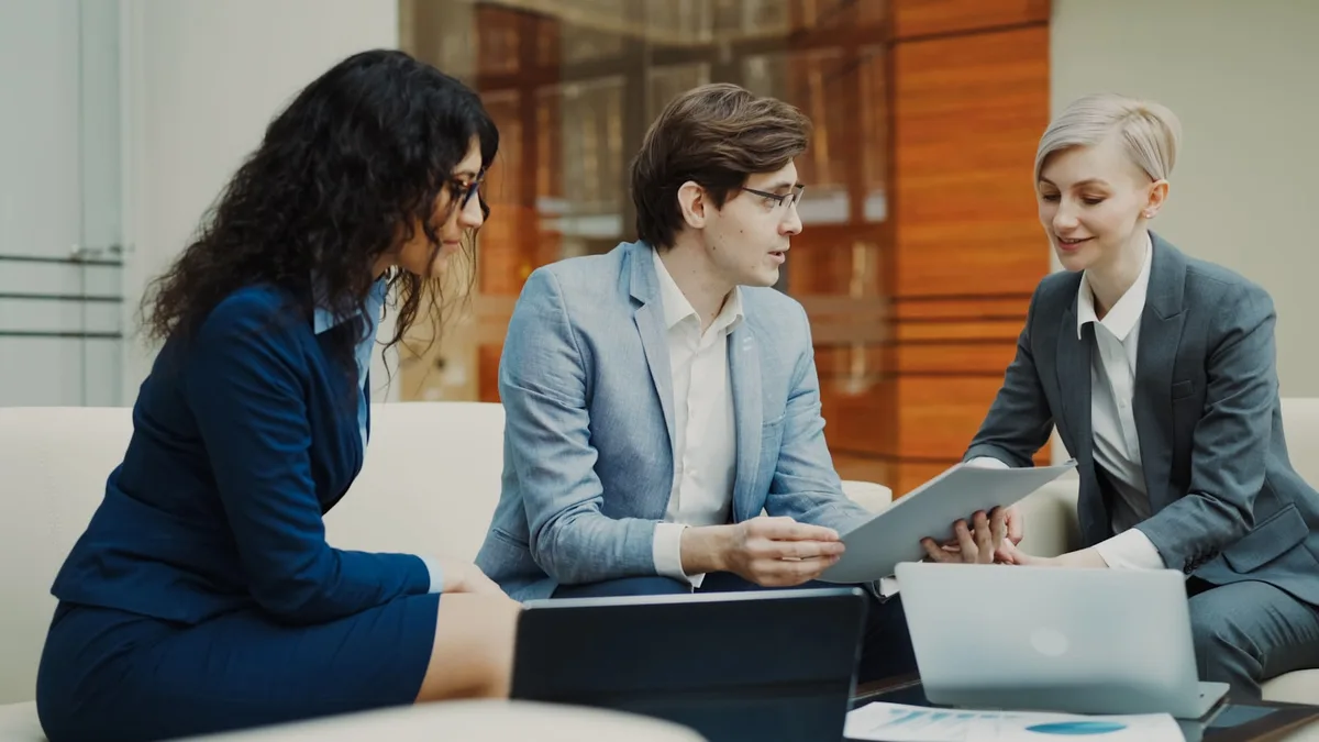 Professional mortgage advisor discussing renewal options with clients at a meeting table