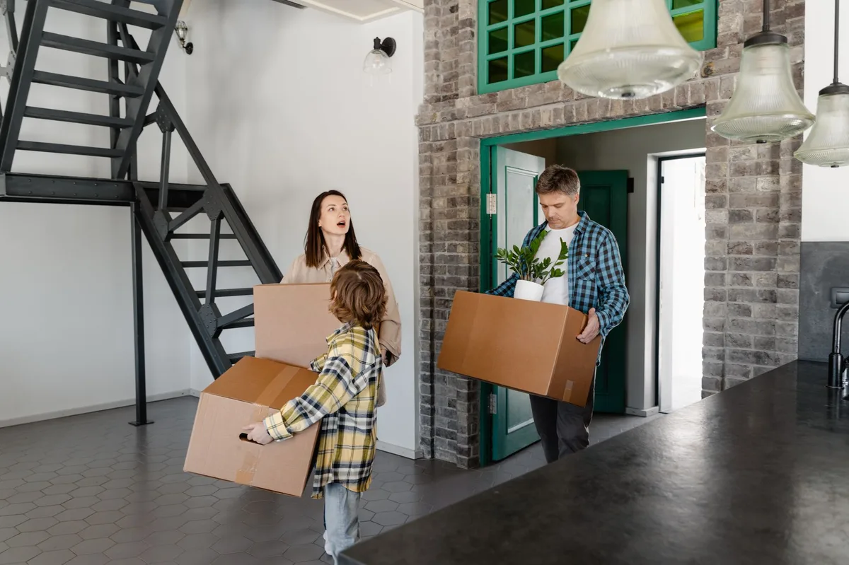 Family carrying moving boxes into their new home
