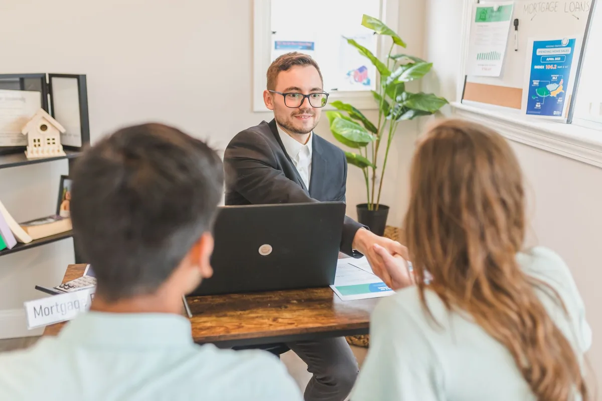 Professional mortgage advisor meeting with first-time home buyers to discuss qualification requirements