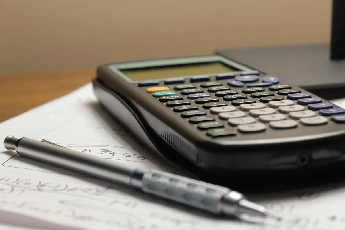 Calculator resting on mortgage documents showing financial calculations