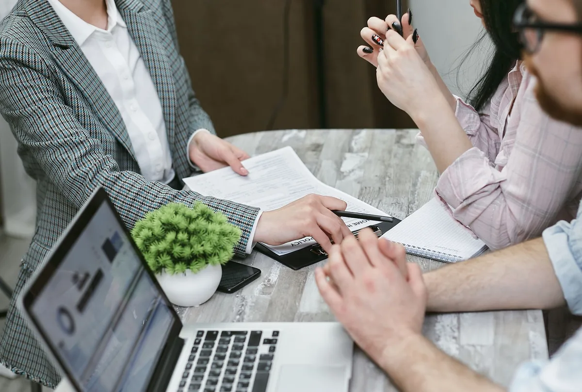 Professional mortgage adviser discussing options with clients at a desk