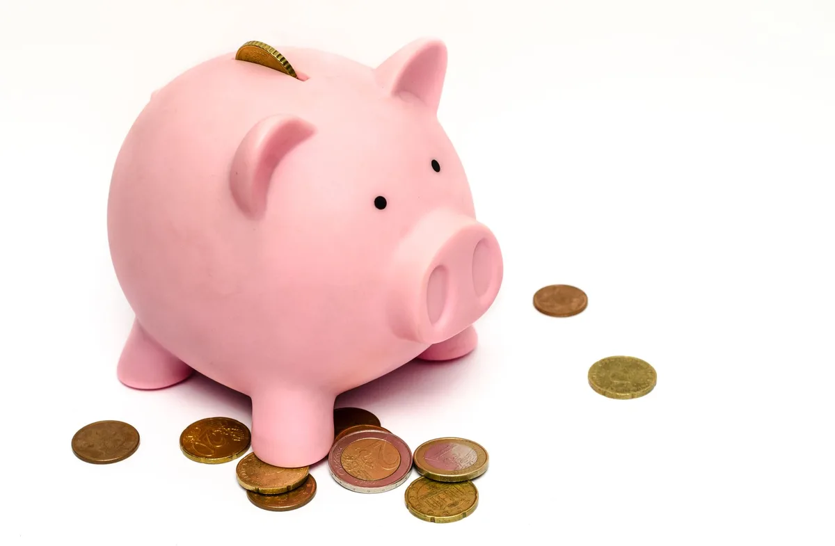 Piggy bank with stacked coins representing mortgage payment savings
