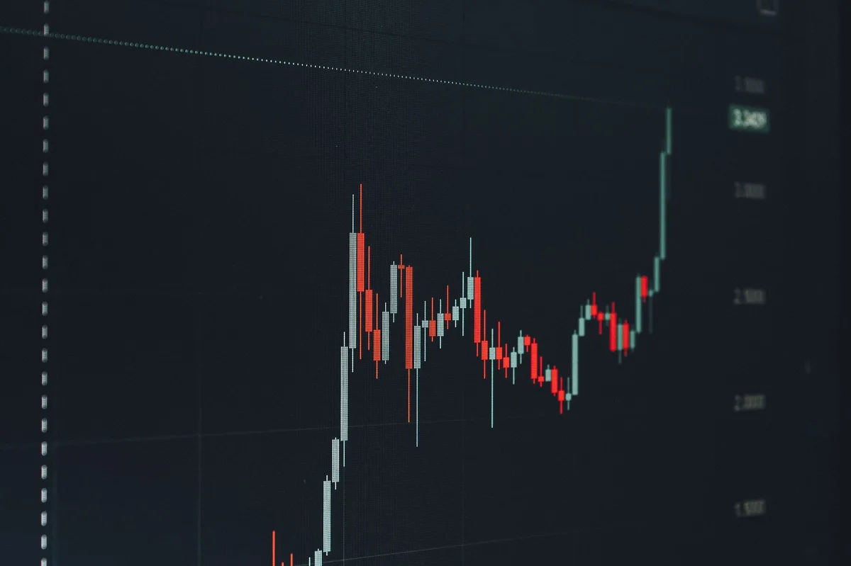 Rising bar chart showing financial growth on paper with pen