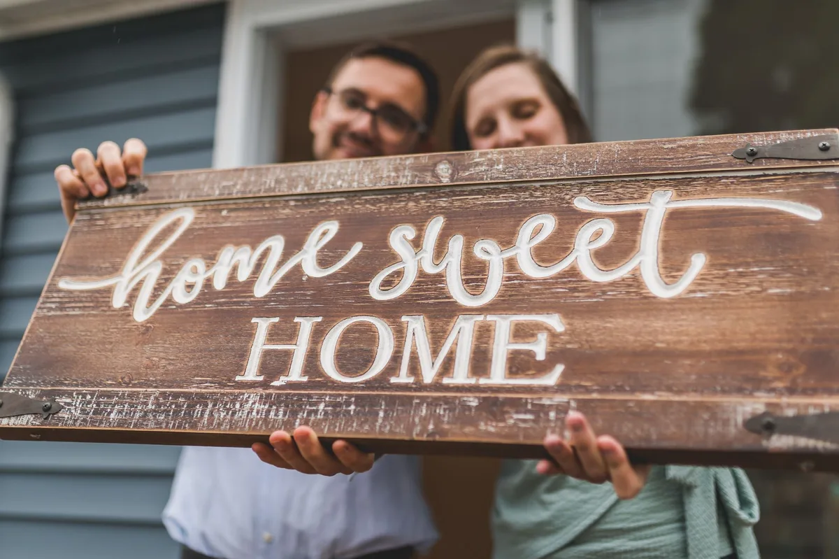 Happy couple holding keys in front of their first home