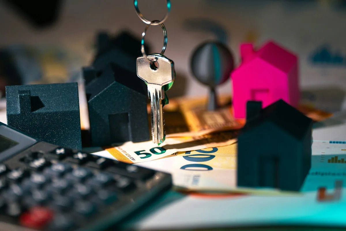 Calculator resting on mortgage documents with pen and paperwork