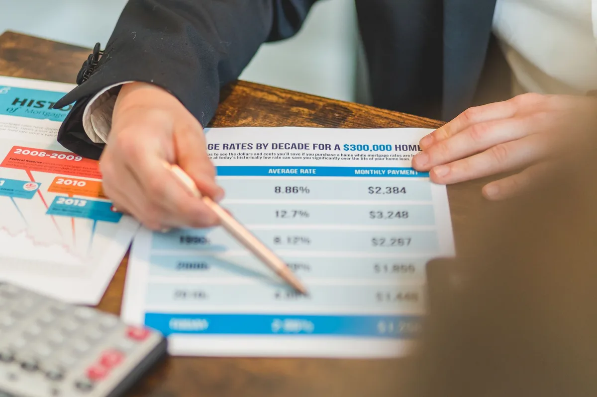 Calculator resting on mortgage documents and financial paperwork