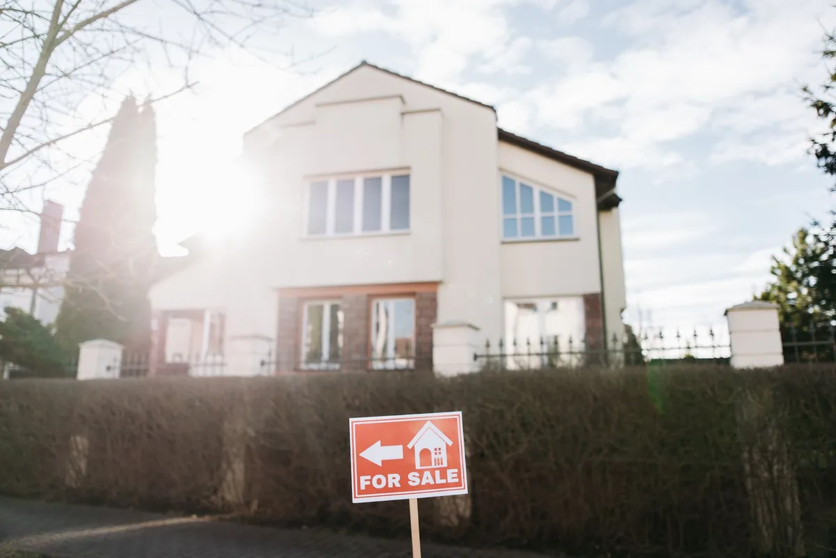 Real estate for sale sign in front of a residential property