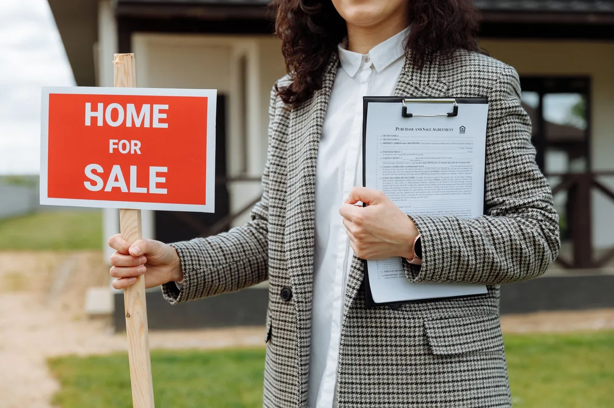 A real estate for sale sign in front of a residential property