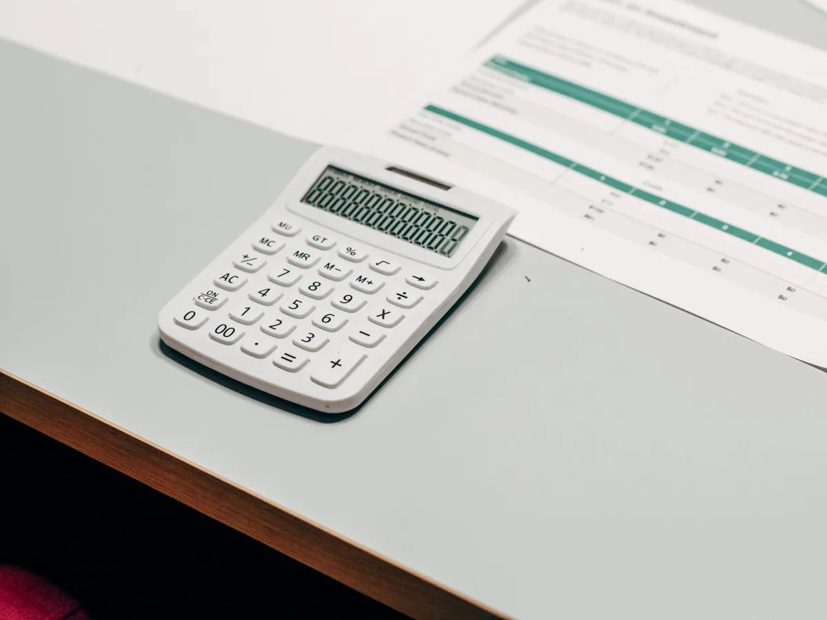 Calculator resting on mortgage documents showing payment breakdown