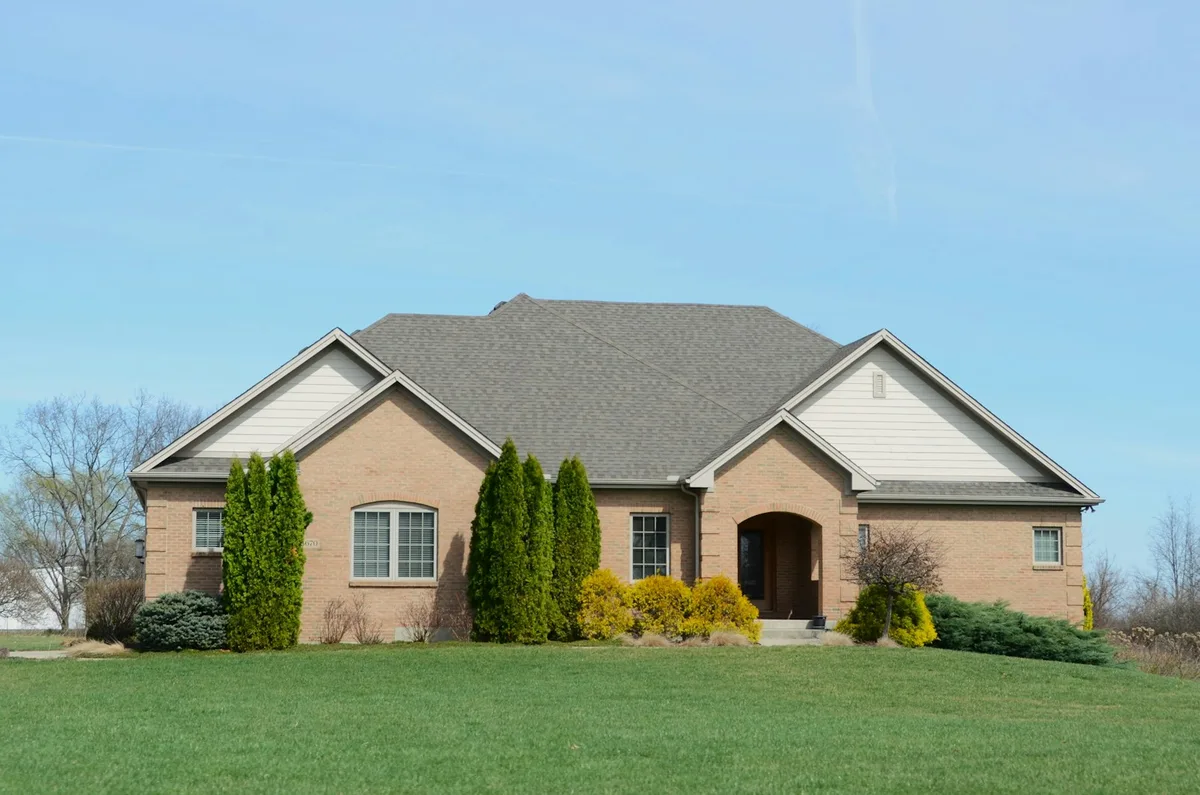 Suburban home with for-sale sign in front yard